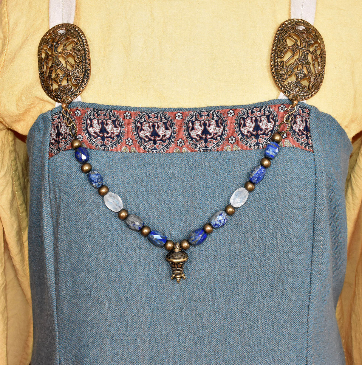 Tragebild am Wikinger Kleid der Edelstein Fibelkette mit großer Bronze-Berlocke – Wikinger Kette mit Lapislazuli und Bergkristall
