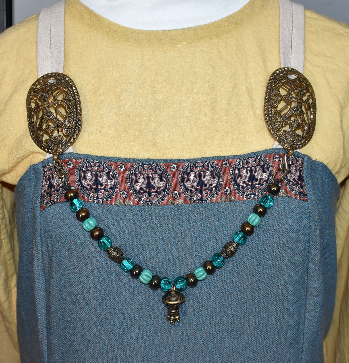 Tragebild am Wikinger-Kleid der Alemannische Fibelkette mit Berlock-Anhänger und meergrünen Glasperlen