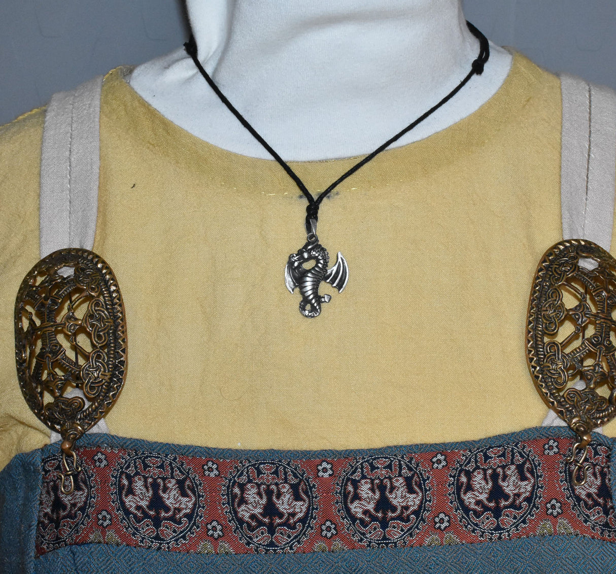 Tragebild der Detailreiner Drachenanhänger aus Zinn an schwarzem Textilband.