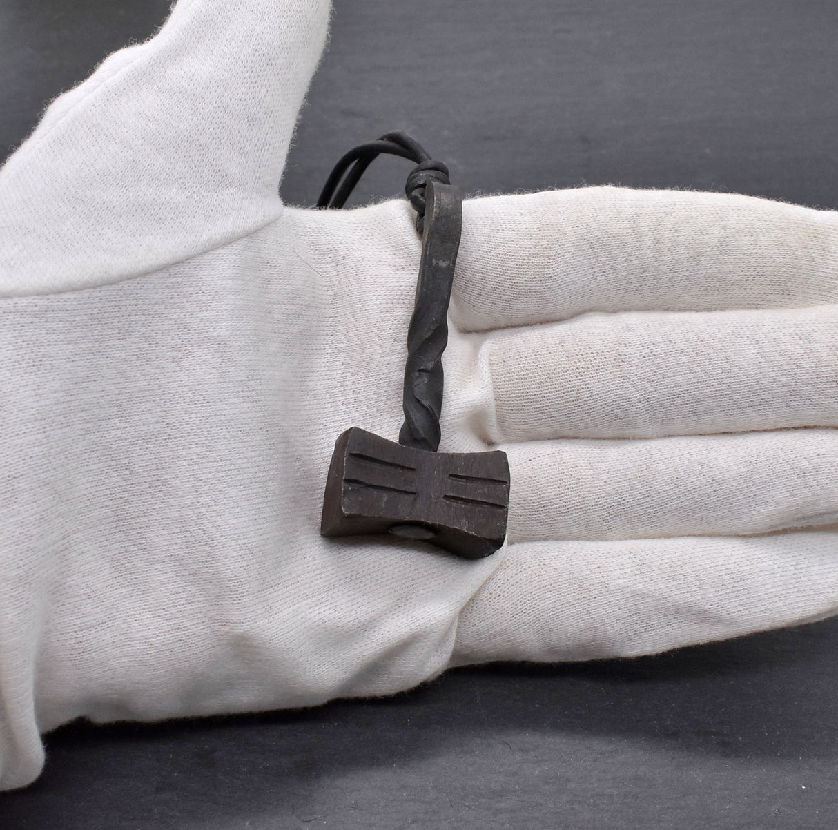 Handgeschmiedeter Mjölnir aus Eisen an einer verstellbaren Lederkette - auf der Hand