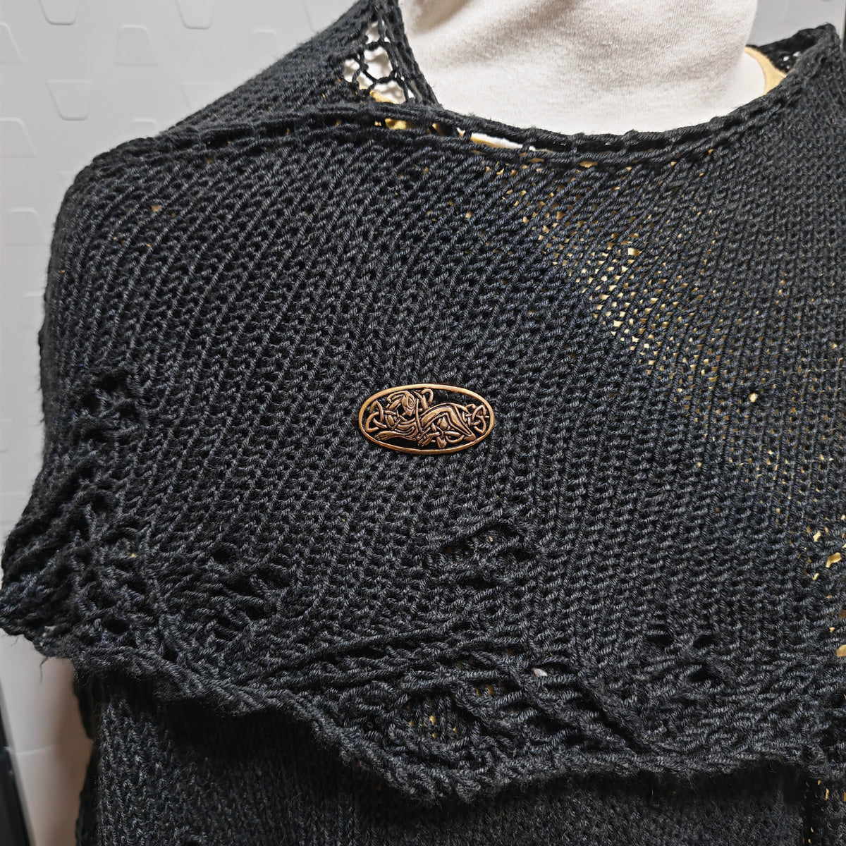 Tragebild an einem schwarzen gestrickten Tuch der Keltischen Brosche mit Hundemotiv aus Bronze