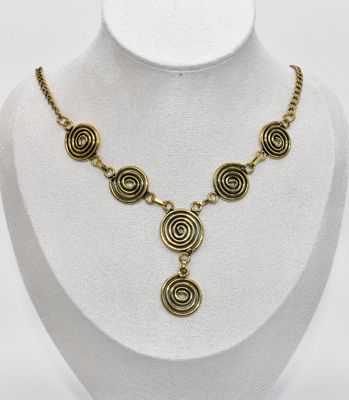 Die Keltische Bronzekette Alin ist ein handgefertigtes Schmuckstück aus hochwertigem Bronzedraht. Das Design besticht durch elegante, runde Spiralen, die mit filigranen Kettengliedern verbunden sind. Der edle bronzene Farbton verleiht der Kette eine zeitlose, mystische Ausstrahlung. Mit einer Länge von etwa 53 cm und einem praktischen Hakenverschluss eignet sich die Kette perfekt für den Alltag oder als besonderes Accessoire zu eleganten Outfits wie Blusen oder Rollkragenpullovern. Ideal für alle, die kelti