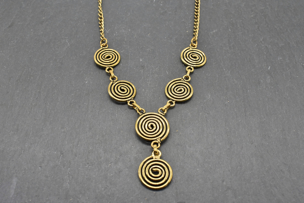 Die Keltische Bronzekette Alin ist ein handgefertigtes Schmuckstück aus hochwertigem Bronzedraht. Das Design besticht durch elegante, runde Spiralen, die mit filigranen Kettengliedern verbunden sind. Der edle bronzene Farbton verleiht der Kette eine zeitlose, mystische Ausstrahlung. Mit einer Länge von etwa 53 cm und einem praktischen Hakenverschluss eignet sich die Kette perfekt für den Alltag oder als besonderes Accessoire zu eleganten Outfits wie Blusen oder Rollkragenpullovern. Ideal für alle, die kelti