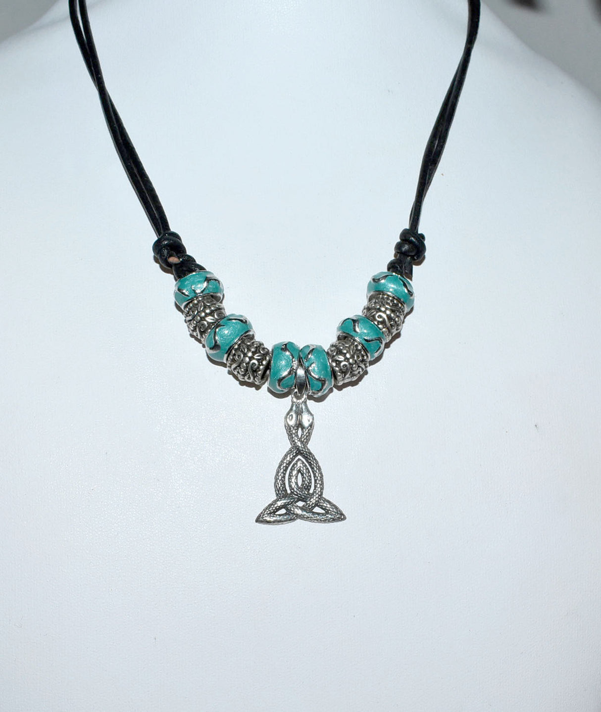 Kyla eine keltische Glasperlenkette mit Triskele als Schlangenamulett auf einem Lederband auf einer Büste