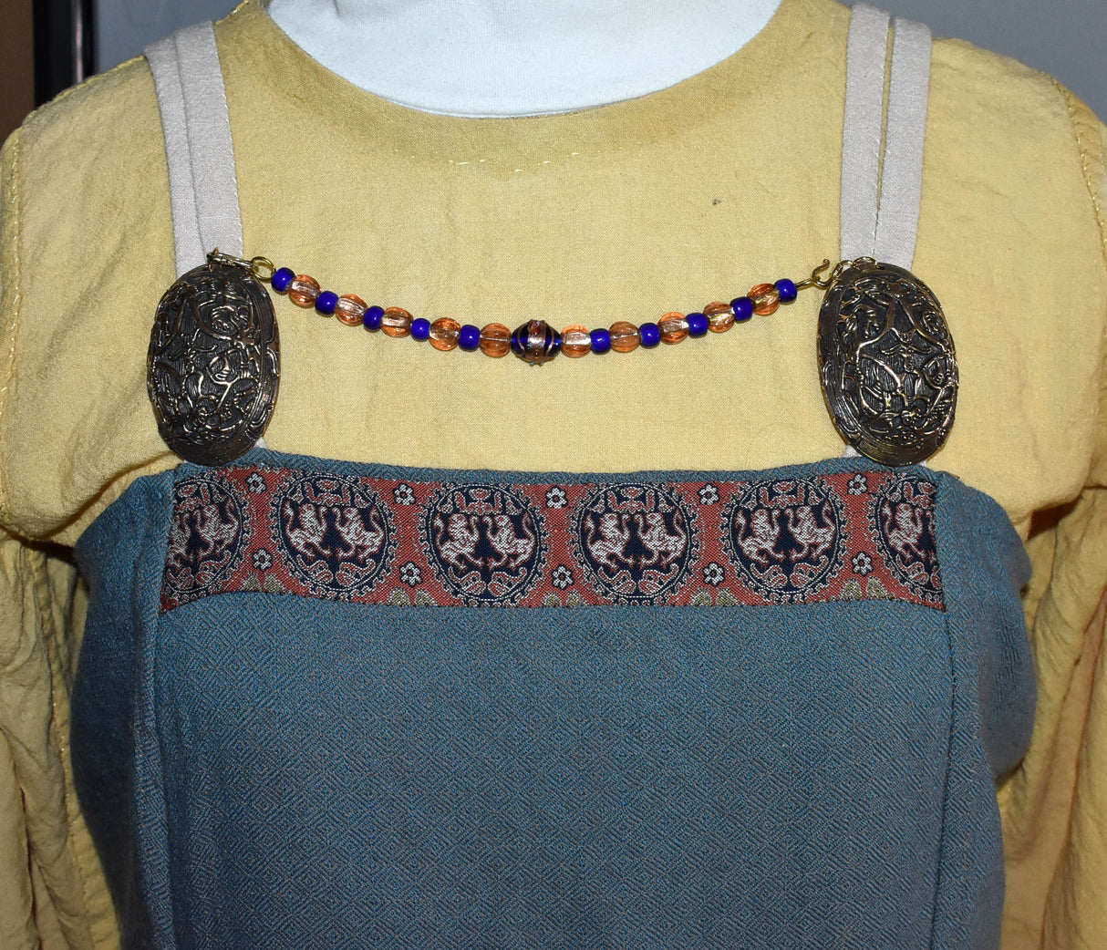 Tragebild am Wikingerkleid der Kurze Fibelkette mit Lampwork-Perlen im Wikinger-Stil – Glasperlenkette für Ovalfibeln und Trägerkleid