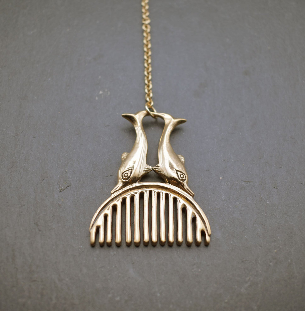 Römischer Bartkamm mit Delphinen aus Bronze an einer Kette