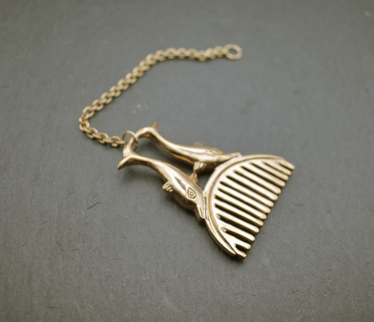Römischer Bartkamm mit Delphinen aus Bronze an einer Kette