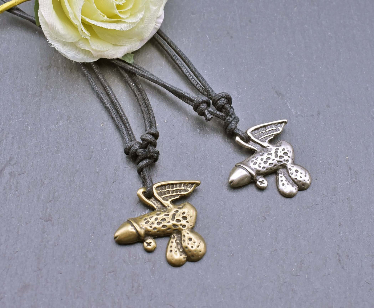 Geflügeltes Phallus-Amulett als humorvolle "Pimmelkette" aus ZAMAK in Messing- und Silberfarben