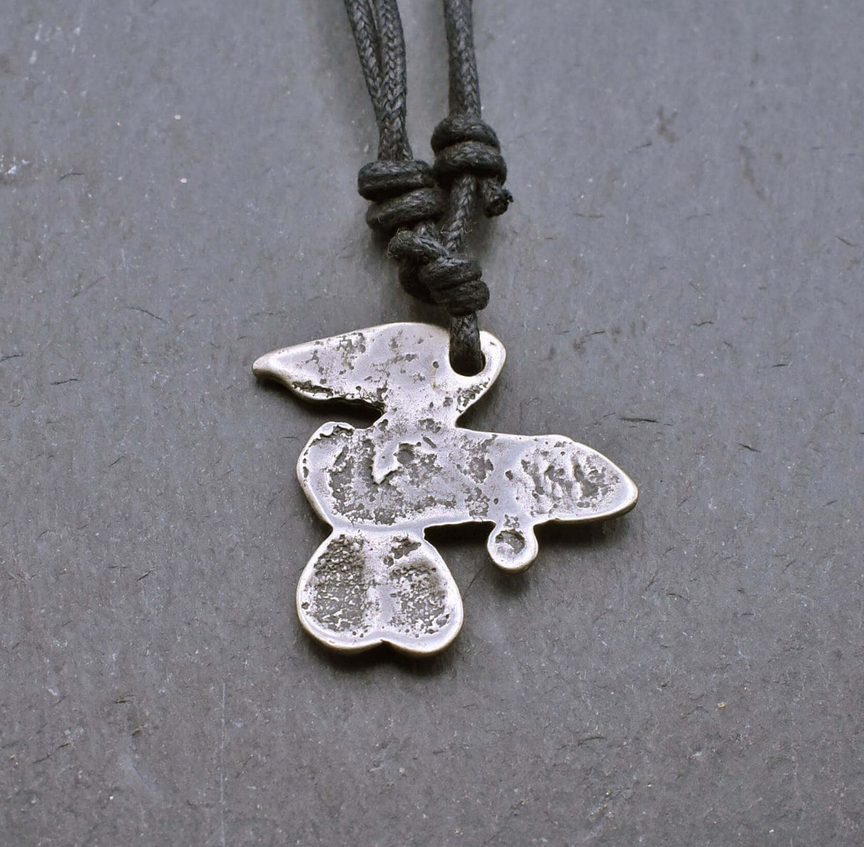 Rückseite des Geflügeltes Phallus-Amulett als humorvolle "Pimmelkette" aus ZAMAK in Silberfarben