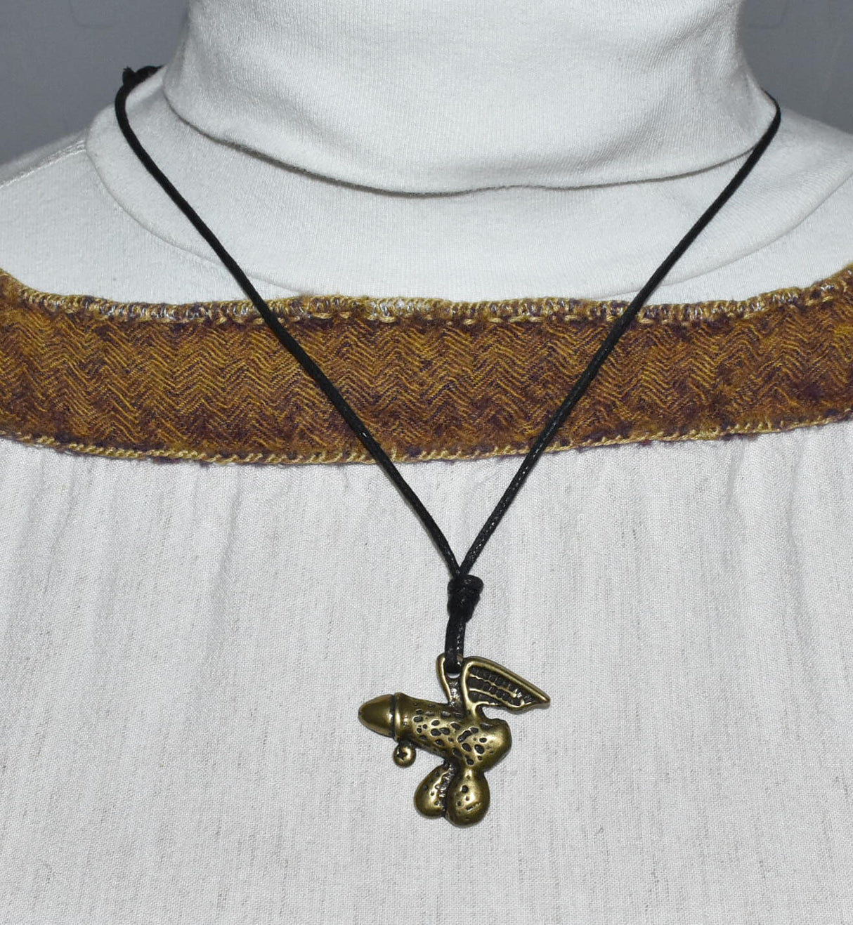 Tragebild des Geflügeltes Phallus-Amulett als humorvolle "Pimmelkette" aus ZAMAK in Messingfarben