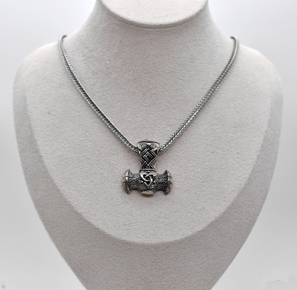 Thorshammer-Kette aus 925er Sterling Silber
Der massiv gearbeitete Thorshammer aus 925er Sterling Silber ist der Mittelpunkt dieser nordisch inspirierten Halskette.
Verschlungene Flechtornamente verzieren den Schaft des Mjölnir, während auf dem Hammerkopf eine Triskele sitzt. Die Vertiefungen sind dunkel abgesetzt und lassen die plastischen Details des Silberanhängers deutlich hervortreten.
Kombiniert ist der etwa 8,5 g schwere Anhänger mit einer 56 cm langen Fuchsschwanzkette aus Edelstahl. Geschlossen