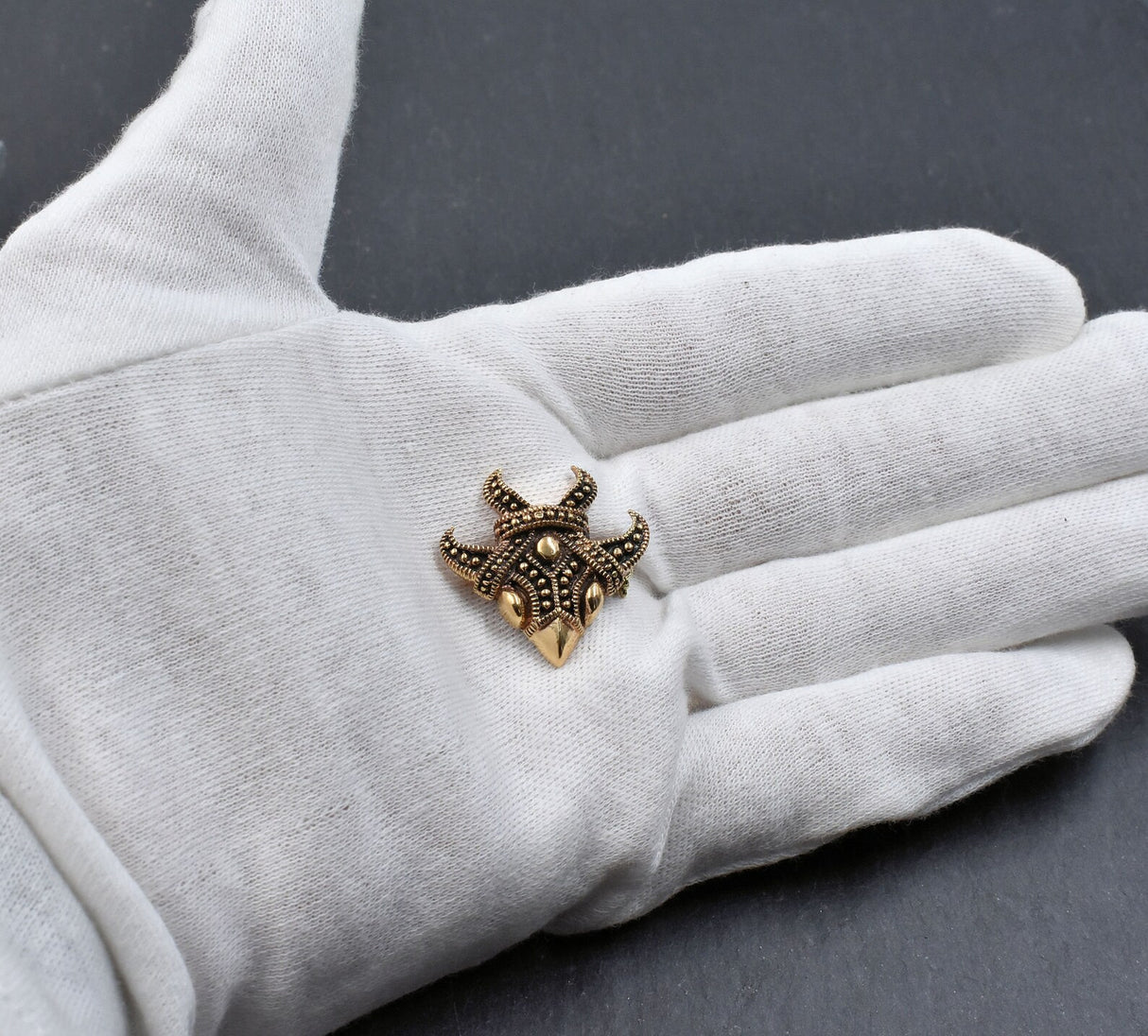 Wikinger Vogelmasken-Brosche aus Bronze auf der Hand