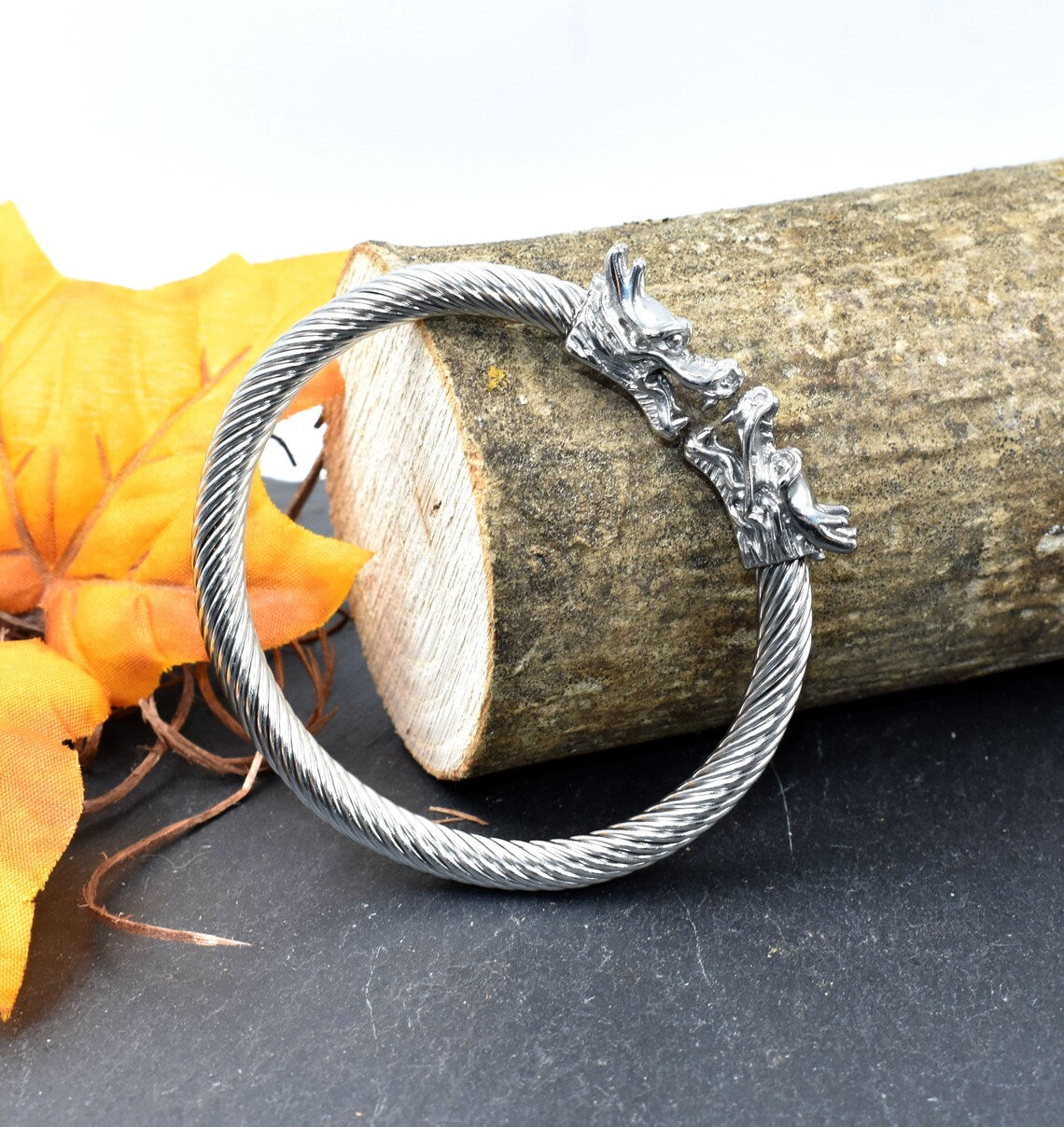 Wikinger Armreif mit Drachenköpfen an einem Stück Holz