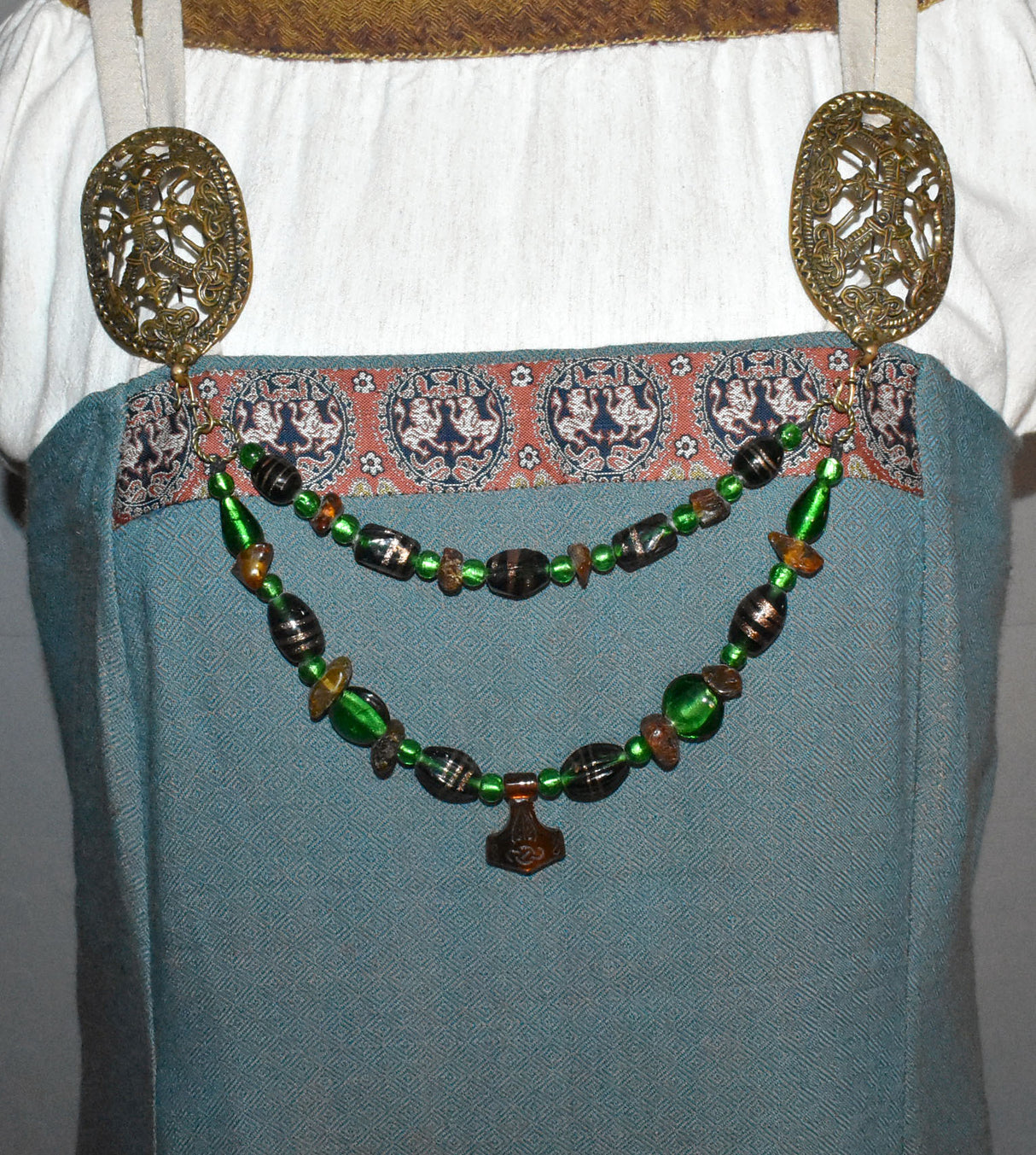 Tragebild der Bernstein Fibelkette mit Thorshammer und grünen Glasperlen