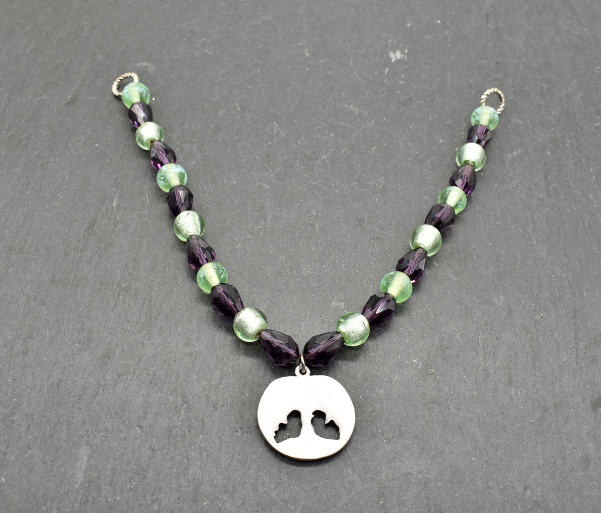 Rückseite der Yggdrasil Fibelkette im Wikinger-Stil – Handgefertigt mit silberfarbenem Anhänger und Glasperlen in hellgrün und dunkellila