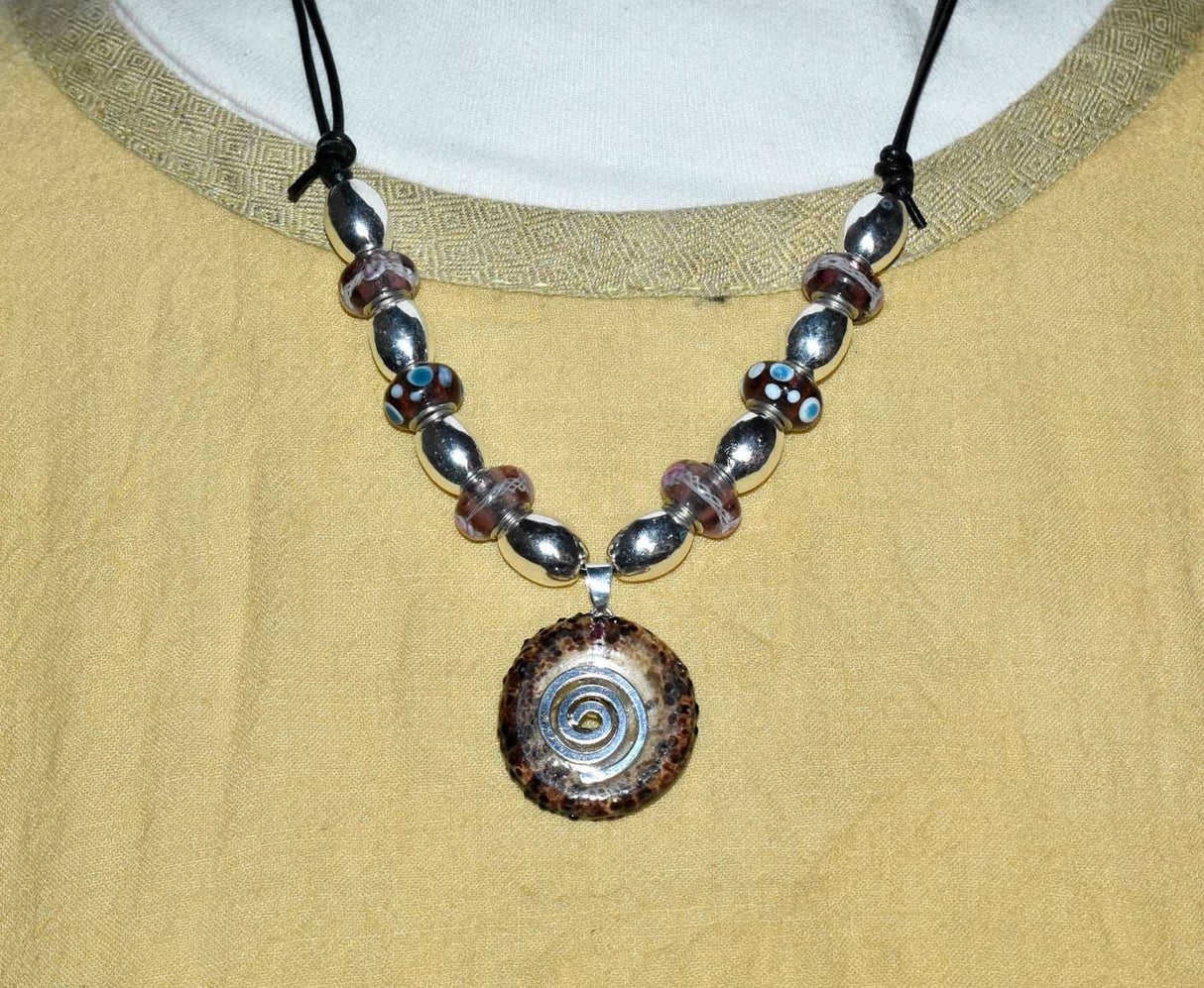 Tragebild der Glasdonut Kette in Flieder und Silber auf einem verstellbaren Lederband