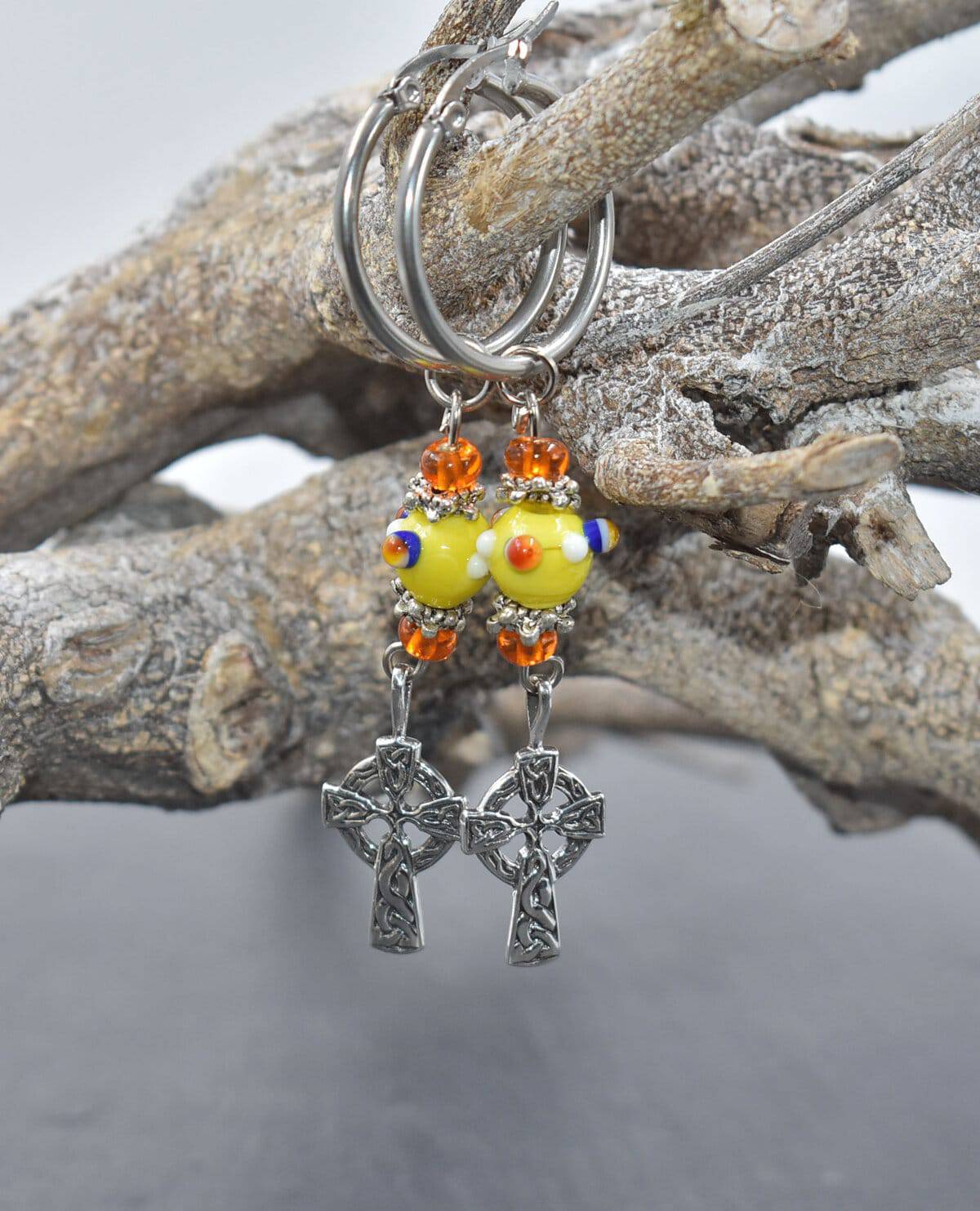 Creolen mit Keltenkreuz mit gelben Lampwork Perlen auf einem Ast