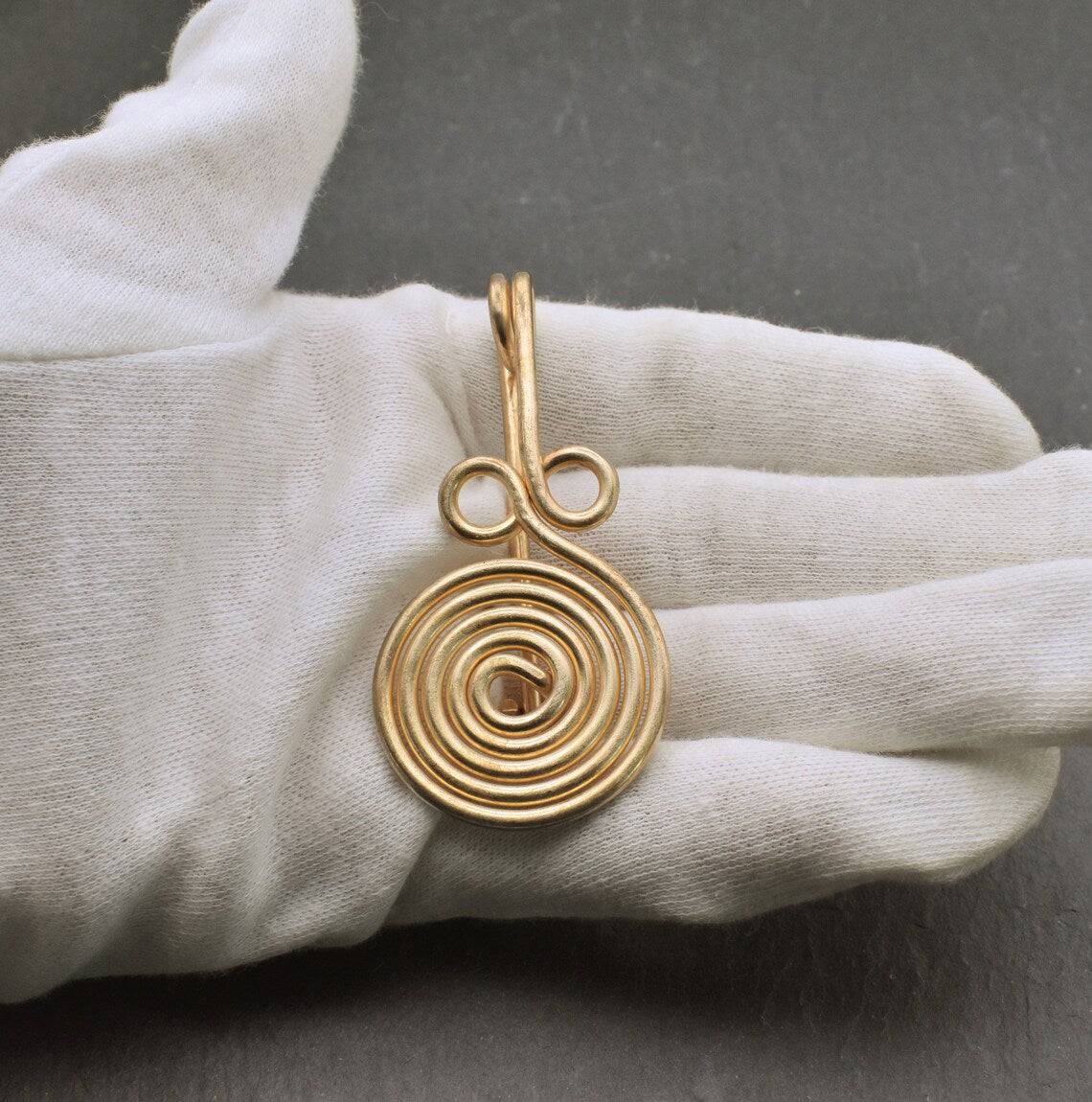 Bronzezeitliche Spiralfibel auf der Hand