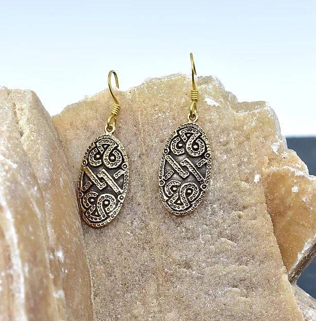 Wikingerschild Ohrringe aus Bronze auf einem Stein