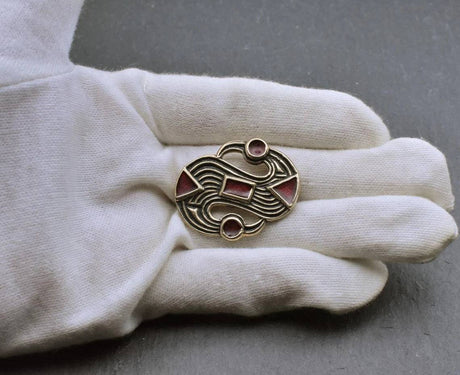 S-Fibel aus der Merowingerzeit aus Bronze auf der Hand