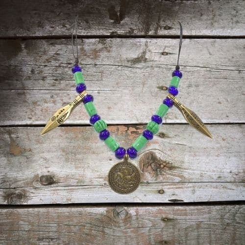 Frühmittelalterliche Halskette mit Odin Bracteat und Glasperlen auf Holz