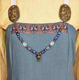 Tragebild am Wikinger Kleid der Edelstein Fibelkette mit großer Bronze-Berlocke – Wikinger Kette mit Lapislazuli und Bergkristall