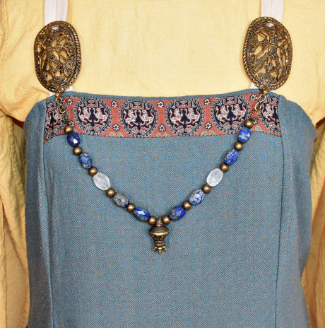 Tragebild am Wikinger Kleid der Edelstein Fibelkette mit großer Bronze-Berlocke – Wikinger Kette mit Lapislazuli und Bergkristall