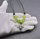 Bienen-Kette "Sumsebienchen" mit grünen Glasperlen auf Lederband auf der Hand