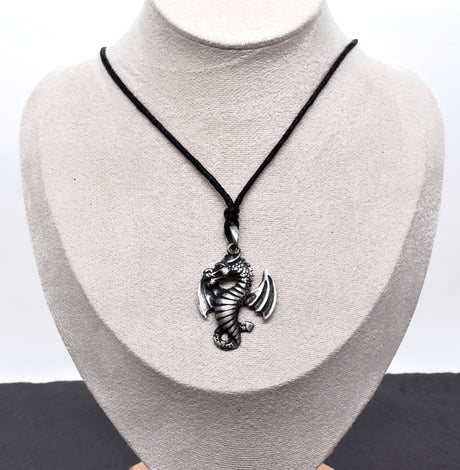 Detailreiner Drachenanhänger aus Zinn an schwarzem Textilband auf einer Büste