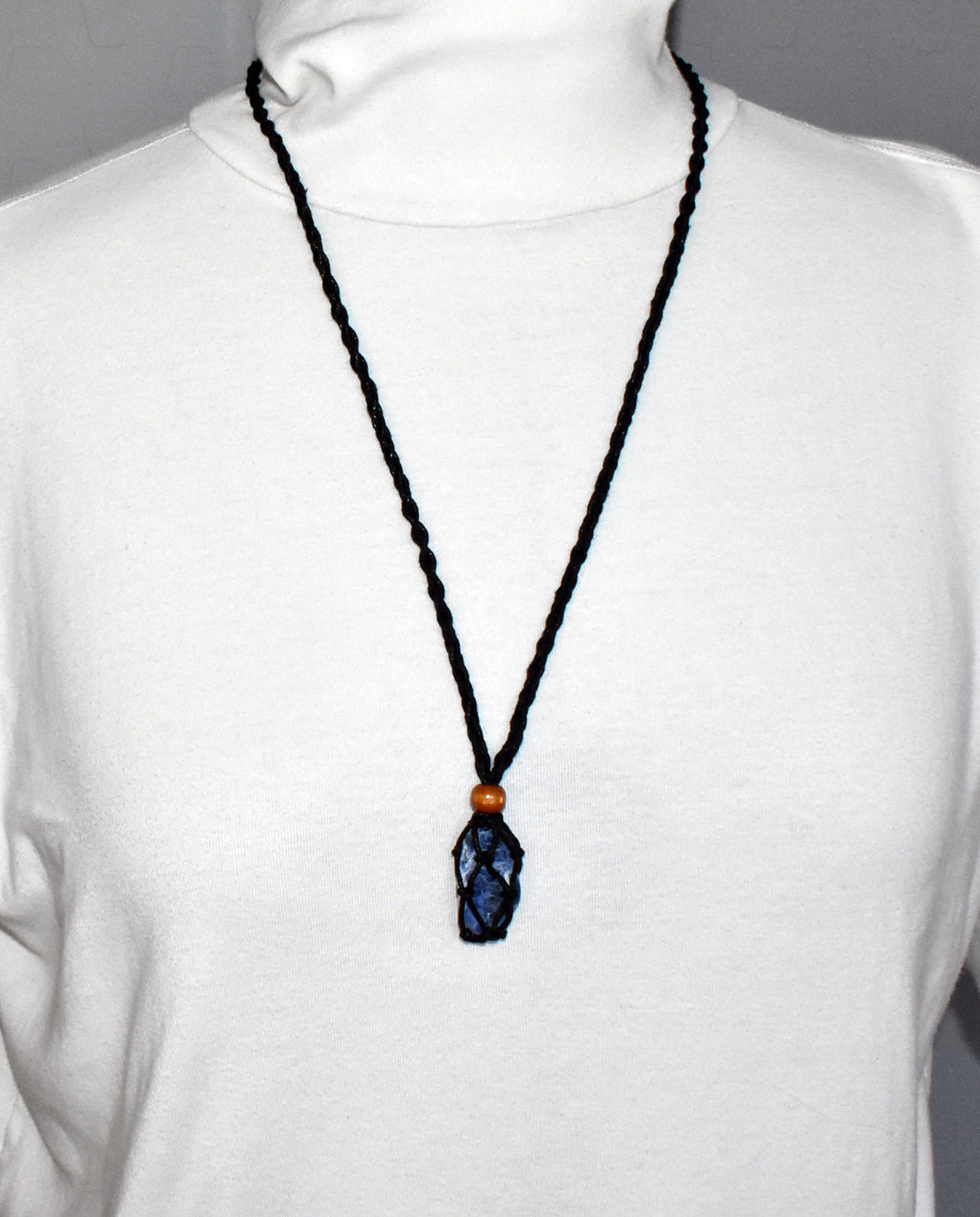 Tragebild auf einem weißen Rollkragenpulver der schwarzen Makramee Kette mit Sodalith