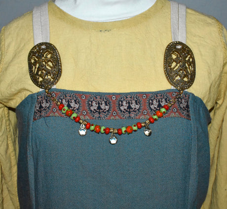 Tragebild am Wikingerkleid der Gotland Fibelkette und Halskette in einem – Handgefertigter Schmuck mit Wikinger-Charme in rot und grün