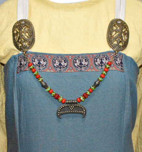 Tragebild am Wikinger Kleid der Slawische Wikinger Fibelkette mit XL Gnedsdovo Lunula aus Bronze – Prunkvolle Glasperlenkette für Wikinger Gewandung in rot und grün