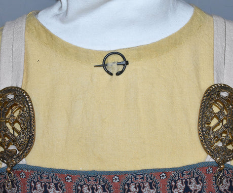 Tragebild der Handgeschmiedete Wikinger Hufeisenfibel aus Eisen. Kleine Gewandnadel für Wadenwickel, Tunika oder Umhang – ideal für Reenactment und LARP.