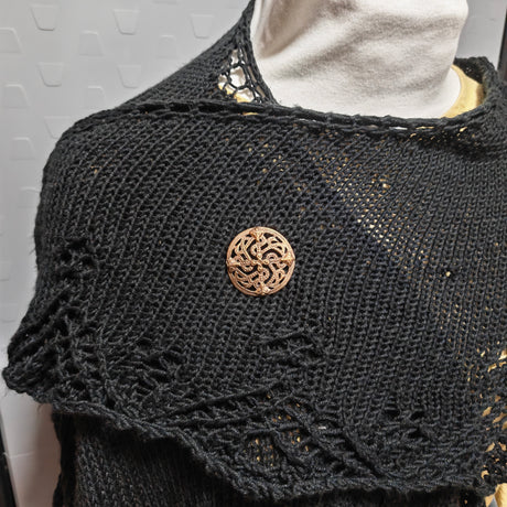 Tragebild der Diese Scheibenfibel aus Bronze ist im Borre-Stil gestaltet, einem charakteristischen Kunststil der Wikingerzeit. Das symmetrisch aufgebaute Ornament greift die verschlungenen Tier- und Flechtmotive auf, die für diesen Stil typisch sind.