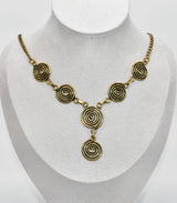 Die Keltische Bronzekette Alin ist ein handgefertigtes Schmuckstück aus hochwertigem Bronzedraht. Das Design besticht durch elegante, runde Spiralen, die mit filigranen Kettengliedern verbunden sind. Der edle bronzene Farbton verleiht der Kette eine zeitlose, mystische Ausstrahlung. Mit einer Länge von etwa 53 cm und einem praktischen Hakenverschluss eignet sich die Kette perfekt für den Alltag oder als besonderes Accessoire zu eleganten Outfits wie Blusen oder Rollkragenpullovern. Ideal für alle, die kelti