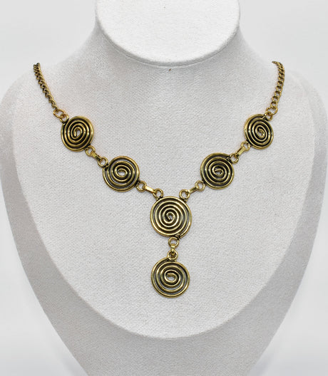 Die Keltische Bronzekette Alin ist ein handgefertigtes Schmuckstück aus hochwertigem Bronzedraht. Das Design besticht durch elegante, runde Spiralen, die mit filigranen Kettengliedern verbunden sind. Der edle bronzene Farbton verleiht der Kette eine zeitlose, mystische Ausstrahlung. Mit einer Länge von etwa 53 cm und einem praktischen Hakenverschluss eignet sich die Kette perfekt für den Alltag oder als besonderes Accessoire zu eleganten Outfits wie Blusen oder Rollkragenpullovern. Ideal für alle, die kelti