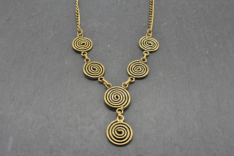 Die Keltische Bronzekette Alin ist ein handgefertigtes Schmuckstück aus hochwertigem Bronzedraht. Das Design besticht durch elegante, runde Spiralen, die mit filigranen Kettengliedern verbunden sind. Der edle bronzene Farbton verleiht der Kette eine zeitlose, mystische Ausstrahlung. Mit einer Länge von etwa 53 cm und einem praktischen Hakenverschluss eignet sich die Kette perfekt für den Alltag oder als besonderes Accessoire zu eleganten Outfits wie Blusen oder Rollkragenpullovern. Ideal für alle, die kelti