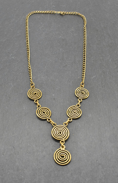 Die Keltische Bronzekette Alin ist ein handgefertigtes Schmuckstück aus hochwertigem Bronzedraht. Das Design besticht durch elegante, runde Spiralen, die mit filigranen Kettengliedern verbunden sind. Der edle bronzene Farbton verleiht der Kette eine zeitlose, mystische Ausstrahlung. Mit einer Länge von etwa 53 cm und einem praktischen Hakenverschluss eignet sich die Kette perfekt für den Alltag oder als besonderes Accessoire zu eleganten Outfits wie Blusen oder Rollkragenpullovern. Ideal für alle, die kelti