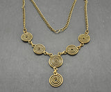 Die Keltische Bronzekette Alin ist ein handgefertigtes Schmuckstück aus hochwertigem Bronzedraht. Das Design besticht durch elegante, runde Spiralen, die mit filigranen Kettengliedern verbunden sind. Der edle bronzene Farbton verleiht der Kette eine zeitlose, mystische Ausstrahlung. Mit einer Länge von etwa 53 cm und einem praktischen Hakenverschluss eignet sich die Kette perfekt für den Alltag oder als besonderes Accessoire zu eleganten Outfits wie Blusen oder Rollkragenpullovern. Ideal für alle, die kelti