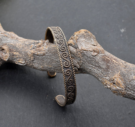 Keltischer Bronzearmreif mit traditionellem Muster auf einem Ast