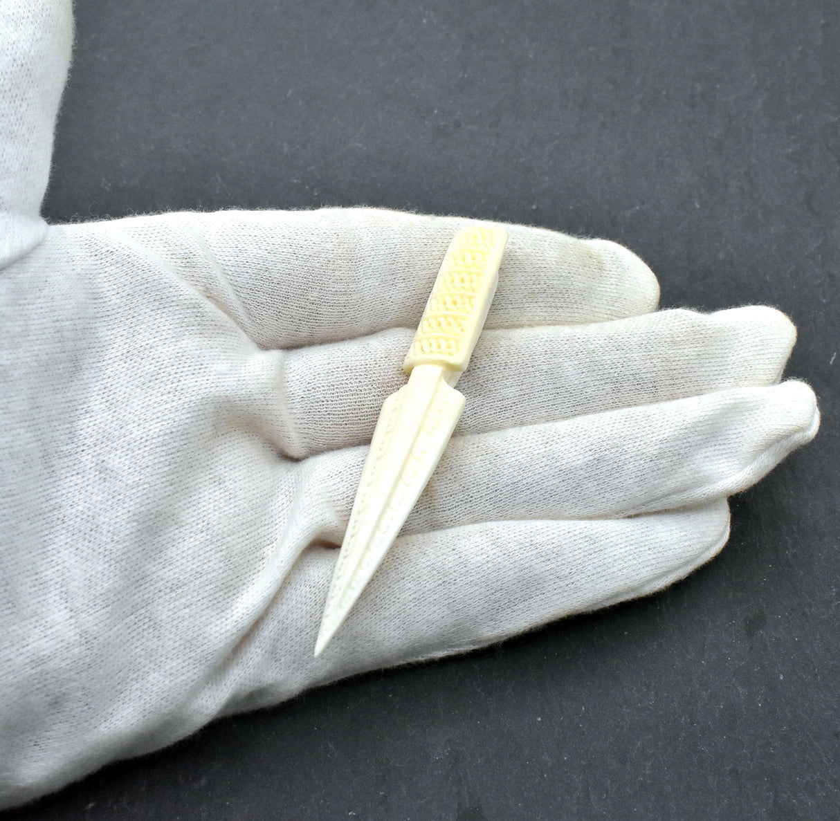 Handgeschnitzte Pfeilspitzen-Krawattennadel und Schal-Klammer aus Rinderknochen auf der Hand