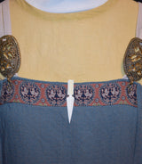 Handgeschnitzte Pfeilspitzen-Krawattennadel und Schal-Klammer aus Rinderknochen an einem Wikingerkleid
