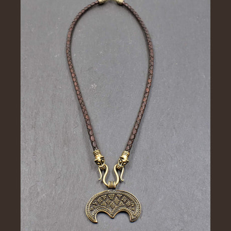 Lunula-Lederkette mit Rabenköpfen

Zwei kunstvoll verzierte Rabenköpfe halten einen Omega-Haken, an dem ein halbmondförmiger Lunula-Anhänger befestigt ist. Die geflochtene Lederkette verbindet damit zwei unterschiedliche historische Schmuckvorbilder aus der Wikingerzeit.