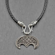 Lunula-Lederkette mit Rabenköpfen

Zwei kunstvoll verzierte Rabenköpfe halten einen Omega-Haken, an dem ein halbmondförmiger Lunula-Anhänger befestigt ist. Die geflochtene Lederkette verbindet damit zwei unterschiedliche historische Schmuckvorbilder aus der Wikingerzeit.