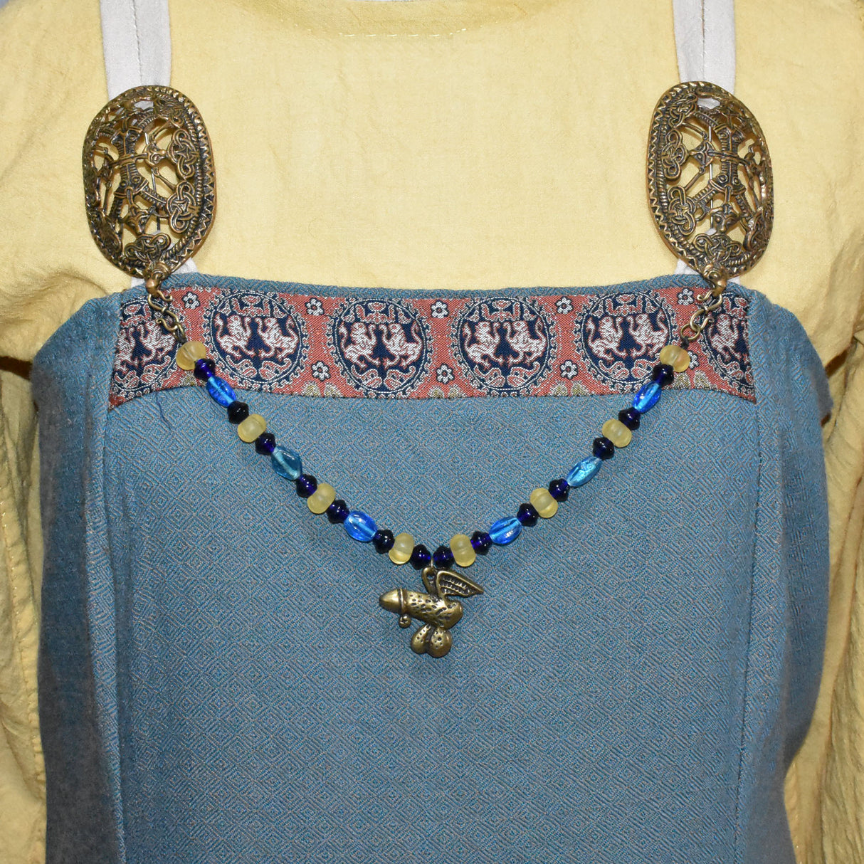 Tragebild der Fibelkette für Mutige mit antikem Phallus-Anhänger – Glasperlen in blau und gelb - Anhänger 