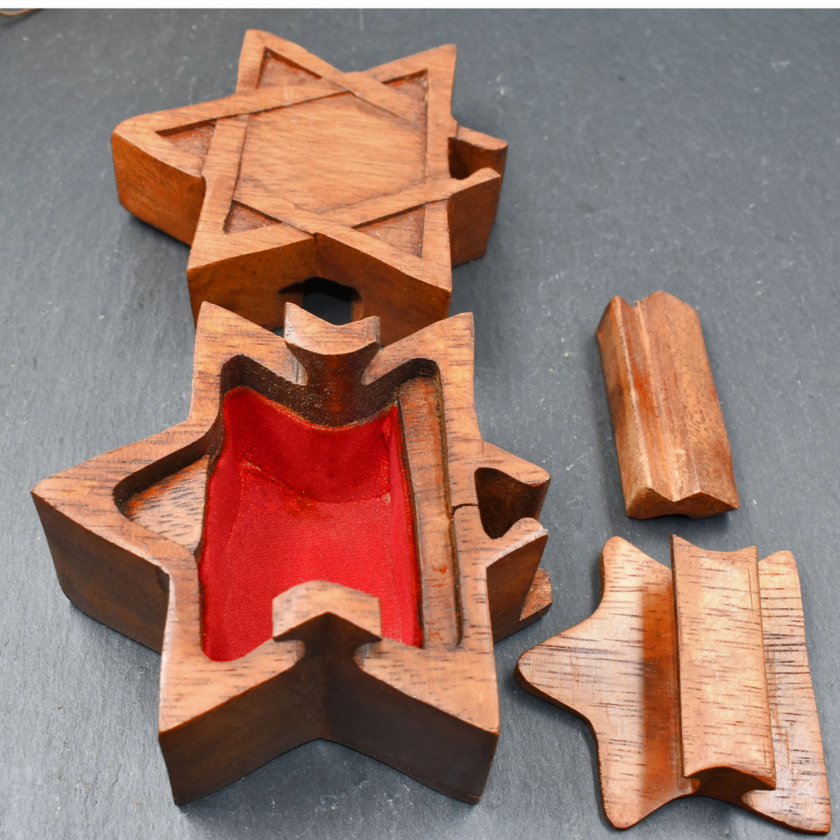 Geöffnete Stern-Puzzledose aus Holz mit Geheimfach

Diese Puzzledose aus Holz verbindet eine dekorative sechszackige Sternform mit einem versteckten Öffnungsmechanismus. Von außen ist zunächst nicht zu erkennen, wie sich die kleine Schatulle öffnen lässt.