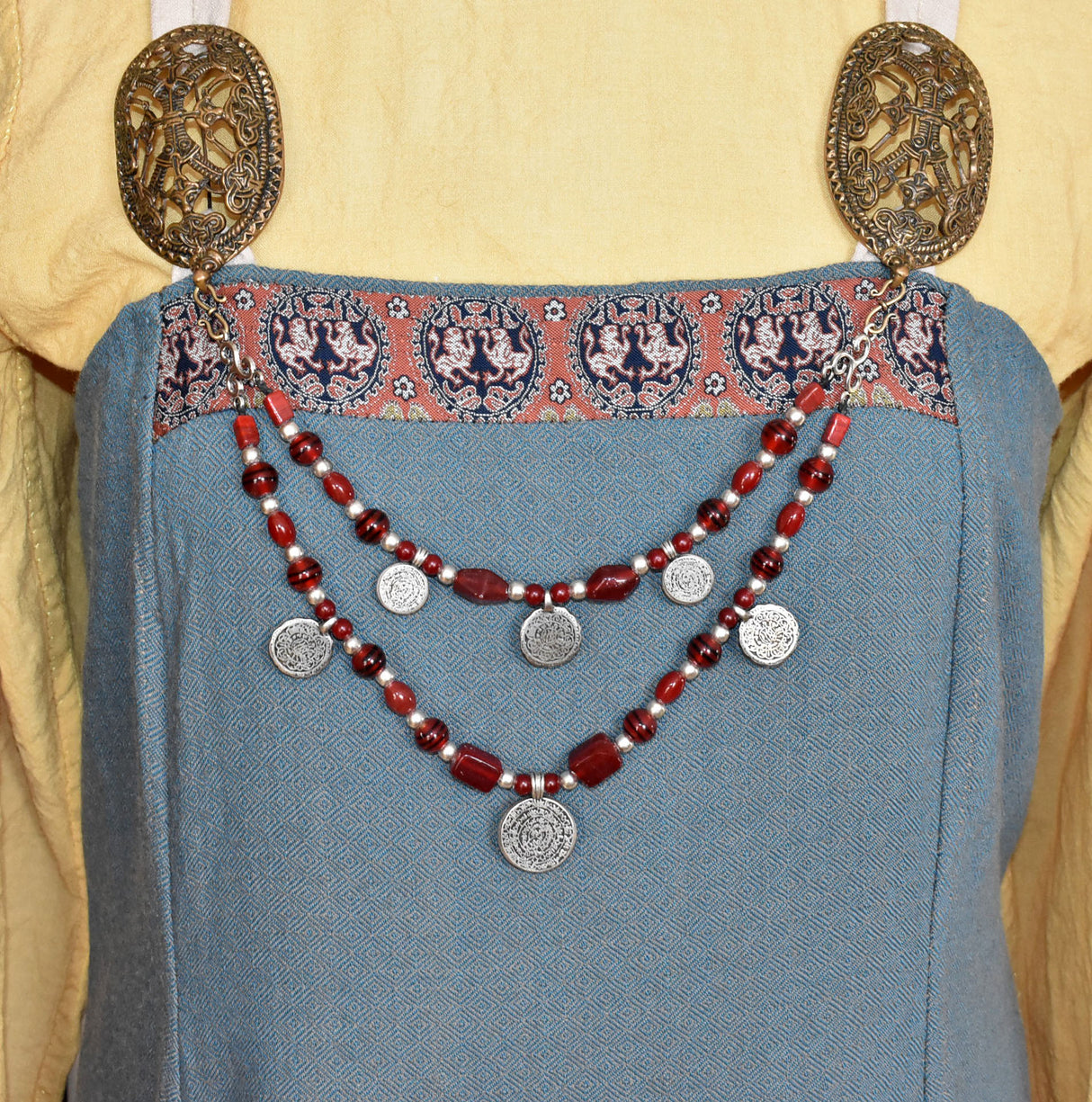 Tragebild am Wikingerkleid der Wikinger Fibelkette mit Triskelen und Münzanhängern mit roten Glasperlen und silbernen Akzenten