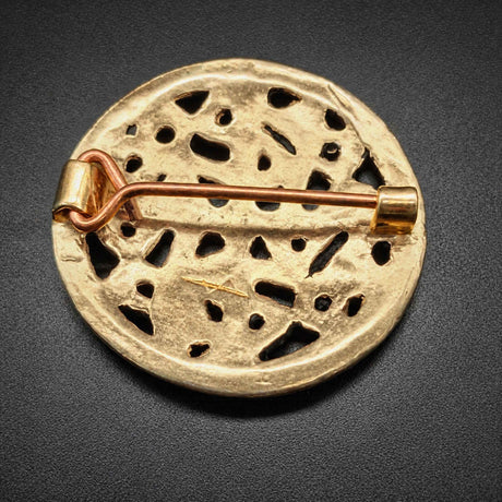 Rückseite der Diese Scheibenfibel aus Bronze ist im Borre-Stil gestaltet, einem charakteristischen Kunststil der Wikingerzeit. Das symmetrisch aufgebaute Ornament greift die verschlungenen Tier- und Flechtmotive auf, die für diesen Stil typisch sind.