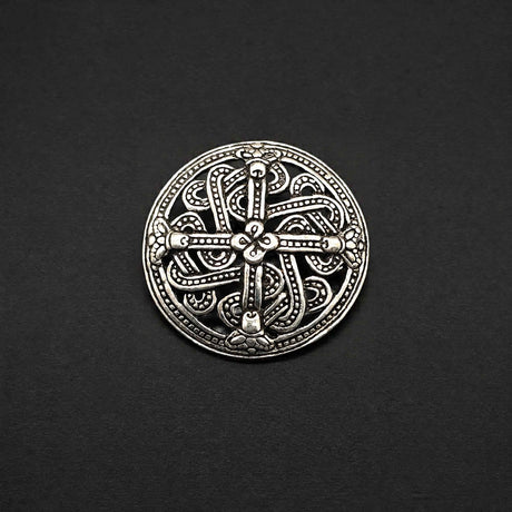 Diese Scheibenfibel aus versilberter Bronze ist im Borre-Stil gestaltet, einem charakteristischen Kunststil der Wikingerzeit. Das symmetrisch aufgebaute Ornament greift die verschlungenen Tier- und Flechtmotive auf, die für diesen Stil typisch sind.
