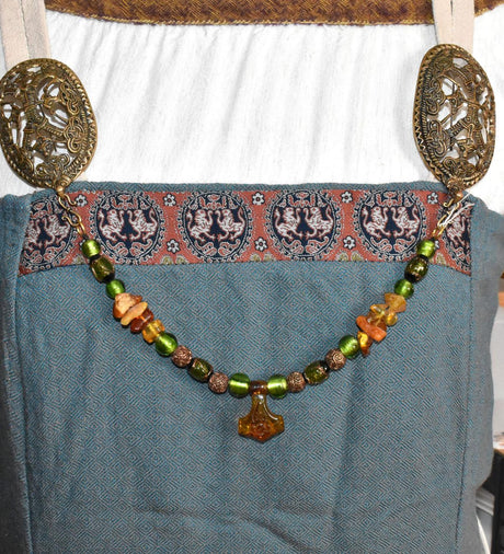 Tragebild am Wikinger-Kleid der Mjölnir-Fibelkette mit Bernstein und grünen Glasperlen